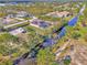 Aerial view of the property with a canal, screened-in pool, solar panels, fenced in yard, boat parking, and red metal roof at 8230 Agate St, Port Charlotte, FL 33981