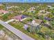 Aerial view of the property shows boat parking behind the house, fenced in yard, and solar panels on the red metal roof at 8230 Agate St, Port Charlotte, FL 33981