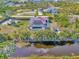 Aerial view of the home with a screened pool, red metal roof, solar panels, boat parking, and canal at 8230 Agate St, Port Charlotte, FL 33981