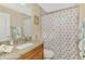 Bathroom with granite counters, wood cabinets, shower and toilet with palm tree shower curtain at 8230 Agate St, Port Charlotte, FL 33981