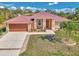 Charming single-story home featuring a metal roof, well-manicured lawn, and attached two-car garage at 8230 Agate St, Port Charlotte, FL 33981