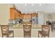 A well-lit kitchen features wood cabinetry, stainless steel appliances, and a granite countertop island with seating at 8230 Agate St, Port Charlotte, FL 33981