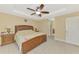 A spacious main bedroom with a tray ceiling features a ceiling fan and coordinating furnishings at 8230 Agate St, Port Charlotte, FL 33981