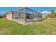 Backyard view of screened-in pool and lush green lawn at 8230 Agate St, Port Charlotte, FL 33981