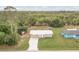 Aerial view of a charming home with a long driveway, surrounded by lush greenery and trees at 11369 1St Ave, Punta Gorda, FL 33955