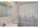 Well-lit bathroom featuring tile walls, a decorative shower curtain, and a sink with a chrome faucet at 11369 1St Ave, Punta Gorda, FL 33955