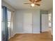 Light-filled bedroom with wood floors, a ceiling fan, and an open doorway to the rest of the home at 11369 1St Ave, Punta Gorda, FL 33955