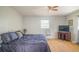 Spacious bedroom with wood-look floors, a ceiling fan, and a large window for natural light at 11369 1St Ave, Punta Gorda, FL 33955