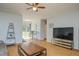 Bright living room featuring wood-look floors, a modern ceiling fan, and sliding glass doors to the backyard at 11369 1St Ave, Punta Gorda, FL 33955