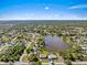 Aerial view showcasing the neighborhood with lush tree coverage and a community lake at 1391 Abalom St, Punta Gorda, FL 33980