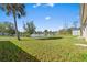 Expansive backyard with lush green grass, palm trees, and a serene lake view at 1391 Abalom St, Punta Gorda, FL 33980