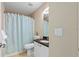 Functional bathroom with tile floors, a shower with blue curtain, a vanity with granite countertop, and a mirror at 1391 Abalom St, Punta Gorda, FL 33980
