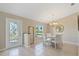 Bright dining room with tile floors, a decorative window-paneled door, chandelier, and a table with four chairs at 1391 Abalom St, Punta Gorda, FL 33980