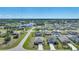 Expansive aerial view of a residential neighborhood with lush greenery, homes, and nearby pond at 149 Hercules Dr, Rotonda West, FL 33947