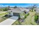 Charming single-story home with a two-car garage, concrete driveway and tropical landscaping at 149 Hercules Dr, Rotonda West, FL 33947