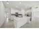 Bright, modern kitchen featuring an island, sleek appliances, white cabinets, and neutral tile floors at 149 Hercules Dr, Rotonda West, FL 33947