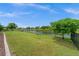 A spacious backyard features lush green grass, a picturesque water view, and a black metal fence at 158 Mariner Ln, Rotonda West, FL 33947