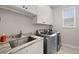 Efficient laundry room with modern machines, storage cabinets, and a granite sink at 158 Mariner Ln, Rotonda West, FL 33947