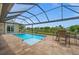 Screened in pool with a patio dining set and a gorgeous view of the water and luscious green scenery at 158 Mariner Ln, Rotonda West, FL 33947