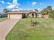 Charming single-story home with a well-manicured lawn, mature trees, and inviting curb appeal at 1909 Johannesberg Rd, North Port, FL 34288