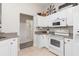 Well-lit kitchen featuring white cabinetry, appliances, and an opening to another room, providing a functional space at 1909 Johannesberg Rd, North Port, FL 34288