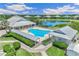 Aerial view of the community pool, clubhouse, lake, and surrounding residential buildings at 2136 Royal Tern Cir, Punta Gorda, FL 33983