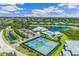 A captivating aerial view showcasing the tennis courts, clubhouse, and a serene pond within the community at 2136 Royal Tern Cir, Punta Gorda, FL 33983