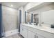 Bright bathroom with a double sink vanity, a large mirror, and a walk-in shower with blue shower curtain at 2136 Royal Tern Cir, Punta Gorda, FL 33983