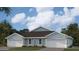 Light blue home featuring a two-car garage, manicured lawn, and tropical landscaping at 2138 Royal Tern Cir, Punta Gorda, FL 33983