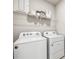 The laundry room features a new washer and dryer with white cabinets and wire shelving at 2138 Royal Tern Cir, Punta Gorda, FL 33983
