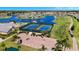 Aerial view of tennis courts and golf cart parking near the community center; manicured lawn at 24036 Buckingham Way, Port Charlotte, FL 33980