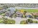 Aerial view of home and community on golf course, and lake; mature landscaping, and paver driveway at 24036 Buckingham Way, Port Charlotte, FL 33980