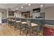 Stylish bar area featuring ample seating, well-stocked shelves, and modern lighting at 24036 Buckingham Way, Port Charlotte, FL 33980