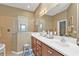 Bright bathroom with dual vanity sinks and walk-in shower with glass enclosure at 24036 Buckingham Way, Port Charlotte, FL 33980