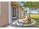 Inviting front entrance with a decorative door, a welcome mat, and lush tropical landscaping at 24036 Buckingham Way, Port Charlotte, FL 33980