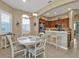Bright kitchen and dining area featuring stainless steel appliances, an island with bar seating, and neutral decor at 24036 Buckingham Way, Port Charlotte, FL 33980