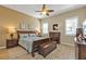 Inviting main bedroom features wood-look floors, ceiling fan and a large dresser at 24036 Buckingham Way, Port Charlotte, FL 33980