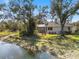 Spacious backyard with lush greenery, pond view, and a screened patio at 2479 Sonoma Dr W, Nokomis, FL 34275