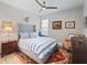 Comfortable bedroom with a tufted headboard, striped bedding, and a ceiling fan for added relaxation at 2479 Sonoma Dr W, Nokomis, FL 34275
