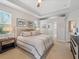A serene main bedroom has neutral tones, tray ceilings, fan, two windows, and an attached en suite at 2479 Sonoma Dr W, Nokomis, FL 34275