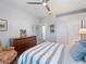 Bright bedroom featuring hardwood floors, soft bedding, and a ceiling fan, exuding comfort at 2479 Sonoma Dr W, Nokomis, FL 34275