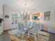 Stylish dining room featuring a contemporary chandelier and a patterned rug, with a modern and inviting atmosphere at 2479 Sonoma Dr W, Nokomis, FL 34275