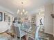 Open-concept dining room with stylish chandelier, adjacent to living area, and ample natural light at 2479 Sonoma Dr W, Nokomis, FL 34275