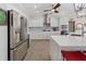 Modern kitchen features stainless steel appliances, white cabinetry, and a spacious island with a quartz countertop at 2479 Sonoma Dr W, Nokomis, FL 34275