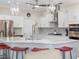 Bright kitchen features stainless steel appliances, white cabinets, a large island, pendant lighting, and seating at 2479 Sonoma Dr W, Nokomis, FL 34275