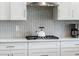 Close up on a modern kitchen with stainless steel vent hood and an eye catching geometric backsplash at 2479 Sonoma Dr W, Nokomis, FL 34275