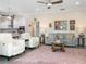 Open concept living room with modern furniture, a large area rug, and an adjacent kitchen area at 2479 Sonoma Dr W, Nokomis, FL 34275