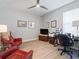 Bright home office featuring hardwood floors, a desk, and a cozy red chair, ideal for productivity at 2479 Sonoma Dr W, Nokomis, FL 34275