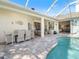 Covered patio boasts dining and lounging areas that extend from a light and bright interior, adjacent to the pool at 2479 Sonoma Dr W, Nokomis, FL 34275