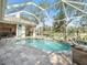 The screened pool offers a serene view, complete with a charming waterfall feature and comfortable seating area at 2479 Sonoma Dr W, Nokomis, FL 34275